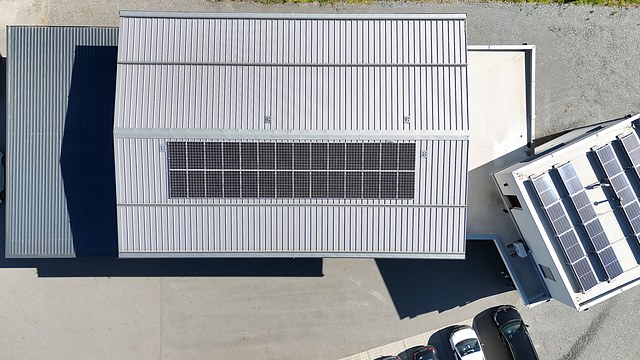 Senkrechte Luftaufnahme eines Hallendachs mit PV-Anlage