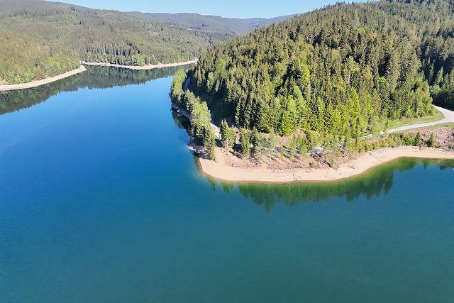 Luftaufnahme eines Stausees mit bewaldetem Ufer